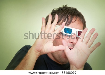 Man with anaglyph 3D glasses making funny face with his hands up.