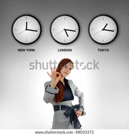 Business woman with clocks showing time in different time zones.