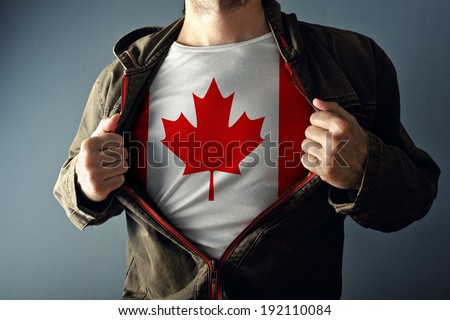 Man stretching jacket to reveal shirt with Canada flag printed. Concept of patriotism and national team supporting.