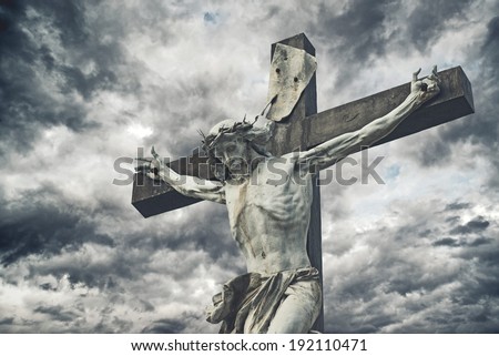 Crucifixion. Christian cross with Jesus Christ statue over stormy clouds. religion and spirituality concept.