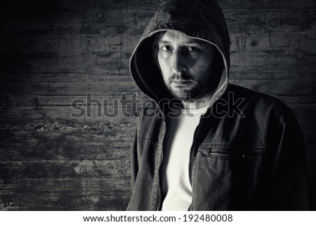 Portrait of unshaven man wearing jacket with hoodie.