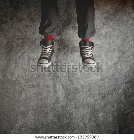 Young man in sneakers jumping high in the air. Concept of freedom and youth spirit.