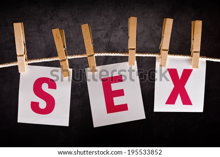 Word sex on notes paper hanging on rope attached with clothespins. Sex education concept.