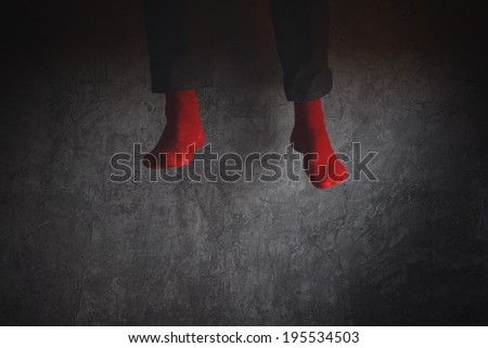 Young man in red socks jumping high in the air in excitement. Concept of freedom, happiness and youth spirit.