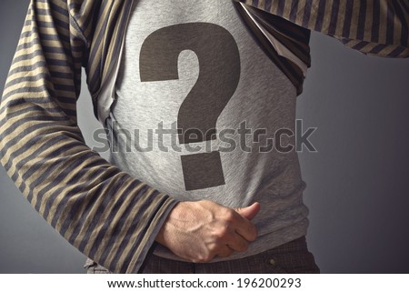 Questioning concept. Casual man showing question mark printed on his shirt.