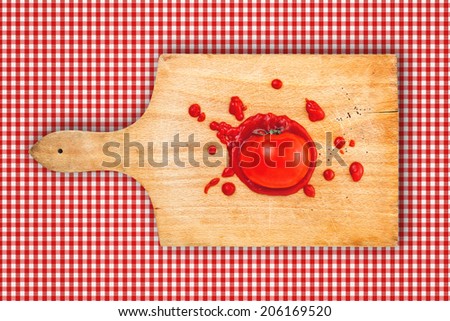 Tomato and ketchup on wooden chop plate board. Splattered tomato with ketchup on kitchen chopping board.