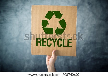 Recycle. Man holding cardboard with Recycle symbol printed, environment preservation activist.
