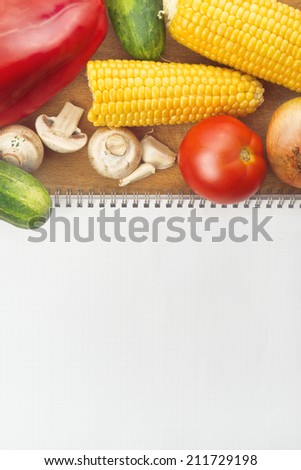 Healthy eating; recipe book as copy space and various raw ripe vegetables on the table