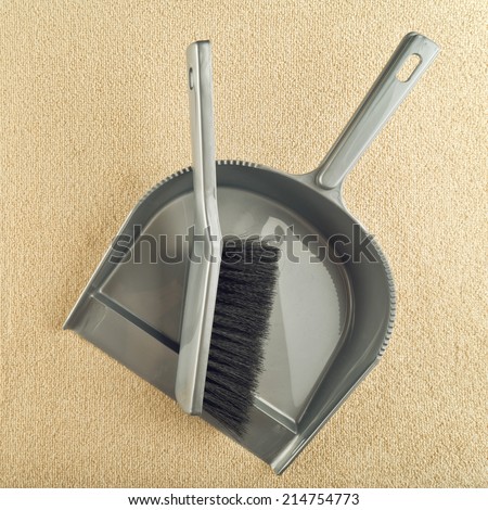 Dustpan and brush floor sweeper on carpet floor. House cleaning work, top view