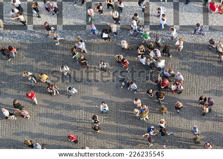 PRAGUE, CZECH REPUBLIC - SEPTEMBER 9, 2014: Aerial Top View of Large group of tourists at Prague central square looking up to Old Town Hall tower.