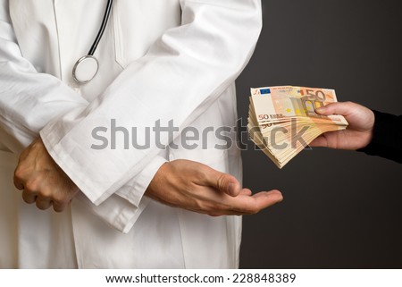 Corruption in Health Care Industry, Doctor receiving large amount of Euro banknotes as a bribe.