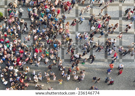 PRAGUE, CZECH REPUBLIC - SEPTEMBER 9, 2014: Top View of Large group of tourists at Prague central square looking up to Old Town Hall tower.