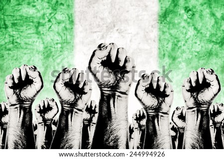 Nigeria Labor movement graphic concept, workers union strike concept with male fists raised in the air fighting for their rights and Nigerian national flag in out of focus background.