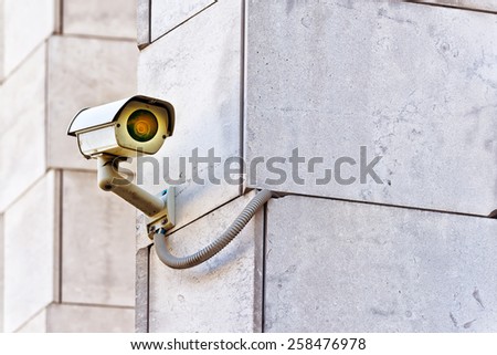 Security CCTV camera mounted on the building wall as apart of private property protection system or Big Brother Concept