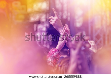 Fans Applauding To Music Band for Live Performing a Concert on Stage in Open Arena, Selective Focus Toned Image with Sun flares.