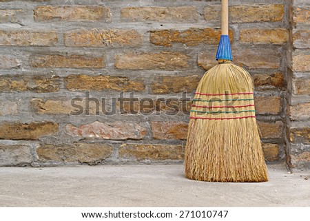 Household Used Broom For Floor Dust Cleaning Leaning on Brick Wall