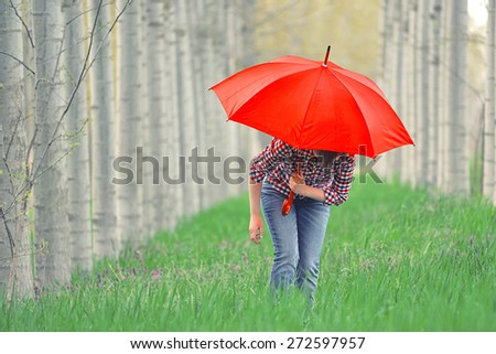 Woman with Red Umbrella In Tree Alley on Cloudy Afternoon