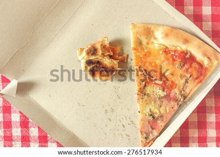 Pizza Slice and Fast Food Leftovers in Cardboard Box on Kitchen Table, Retro Style Toned Image, Selective Focus with Shallow Depth of Field