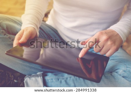 Creative Woman with Digital Tablet Computer in Casual Clothing Browsing the Internet in Search for Inspiration.