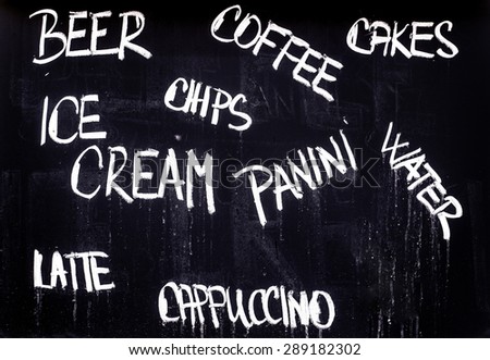Restaurant Advertising Blackboard with Beverage, Food and Drink Refreshment Drinks List Written in Chalk: Beer, Coffee, Cakes, Ice Cream, Chips, Panini, Water, Latte, Cappuccino.