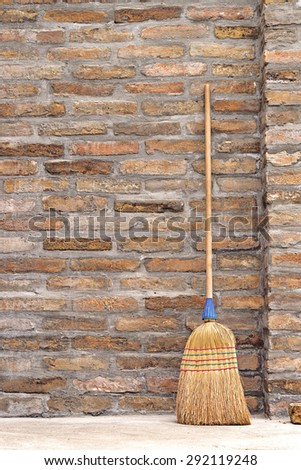 Household Used Broom For Floor Dust Cleaning Leaning on Brick Wall
