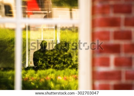 People in the House, Silhouettes of Unrecognizable Man and Woman Indoor Viewed from Outside Through House Window