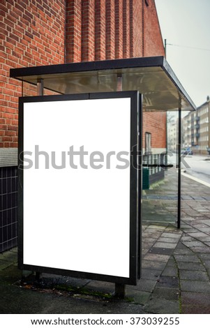 Blank bus stop advertising billboard on empty street as copy space for outdoor poster ad mock up.