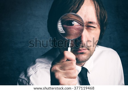 Businessman with magnifying glass, tax inspector doing financial auditing or consultancy, retro toned, selective focus