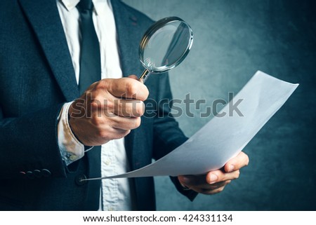 Tax inspector investigating financial documents through magnifying glass, forensic accounting or financial forensics, inspecting offshore company financial papers, documents and reports.