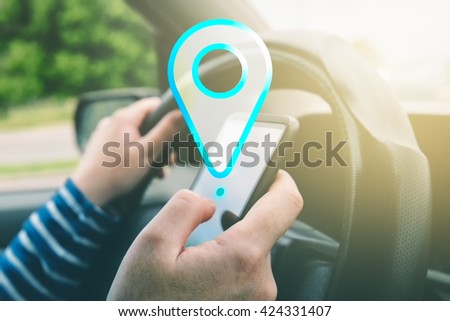 Female driving car and using gps navigation app on smartphone to find destination, using mobile phone in traffic.