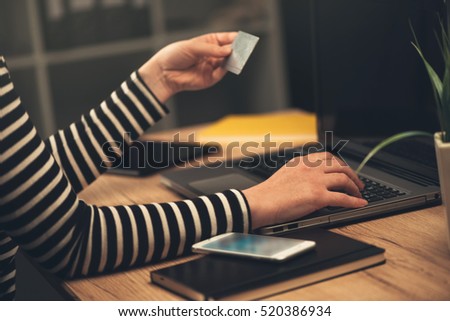 Laptop computer shopping online from office, businesswoman using debit payment card to purchase items on internet, selective focus.
