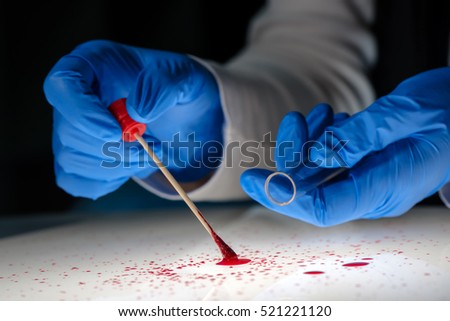 Forensic technician taking DNA sample from blood stain with cotton swab on murder crime scene.