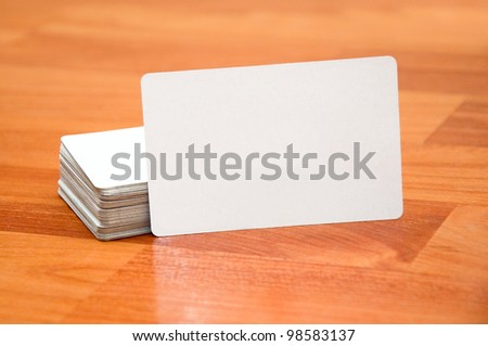 Stack of business cards with rounded corners on wood background