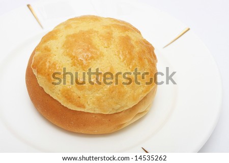 Pineapple bun (Hong Kong pastry) on white plate.