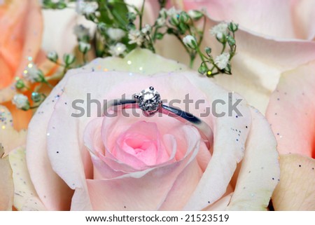 A diamond ring put on pink rose.