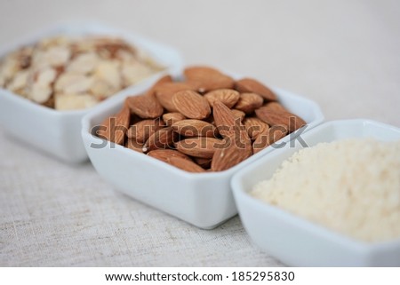 Almonds, almond flour and sliced almonds in bowls. Selective focus