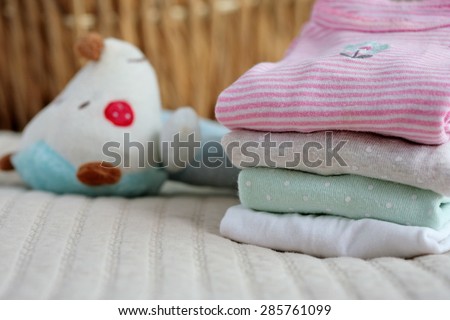 Pile of baby clothes and a toy