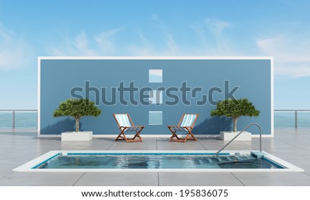 Pool on waterfront with two deckchair and plants in front a blue wall