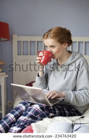 Young woman with laptop and coffee mug