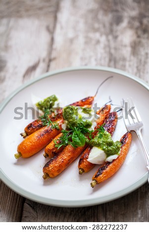 Roast carrots with mozzarella, pesto and carrot tops garnish
