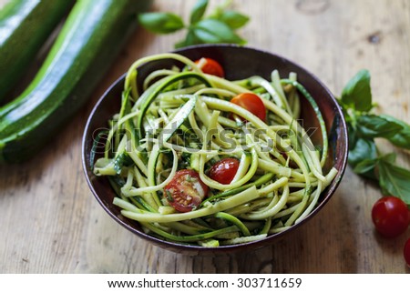 Zucchini spaghetti with rough basil and walnut pesto and cherry tomatoes