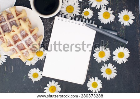 sketch book, pen waffles and coffee on a table decorated with flowers, mock up