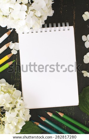 sketch book, flowers of hydrangea and color pencils in green and white tones, mock up