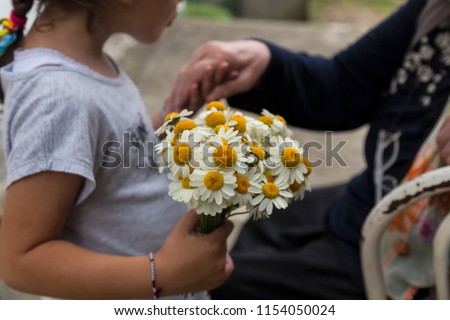 celebrate the feast of the elders.happy mother day.kiss the mum hand.woman and kid hold the daisy.