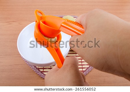 Lemon Squeezer with lemons and juice on wooden background.