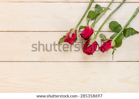 Valentines day background with red roses on wood texture for background.