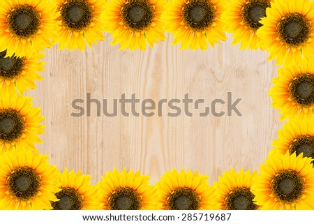 Frame of garden tools and flowers. Yellow sunflowers on wood background.
