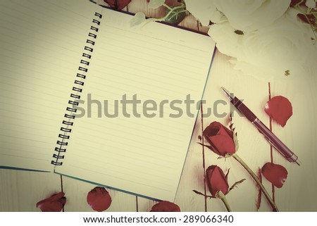 Vintage style - Red rose flower and Notepad book on wood texture.