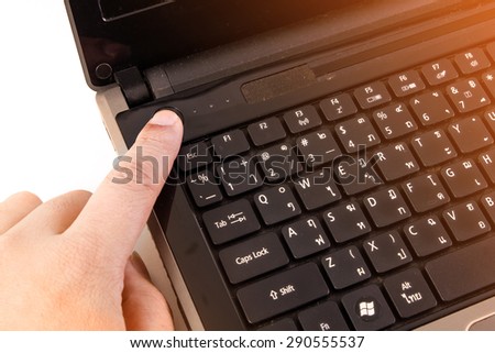 Close-up of Man finger pushing the button of laptop keyboard.