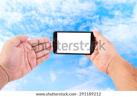 Man hand hold blank touch screen smart phone on blue sky background.